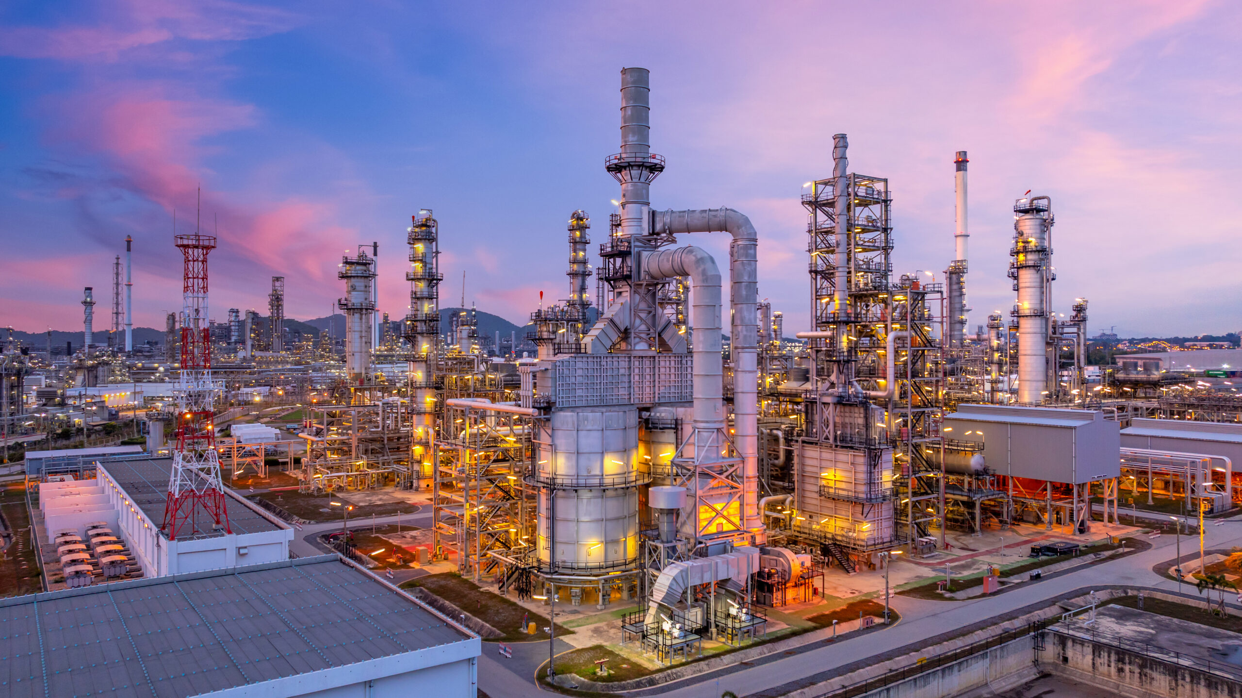 Aerial view oil and gas refinery plant at night, Global business energy logistic transportation, Oil and gas refinery petrochemical industrial, Petrochemical refinery industrial energy supply chain. Aerial view oil and gas refinery plant at night, Global business energy logistic transportation, Oil and gas refinery petrochemical industrial, Petrochemical refinery industrial energy supply chain.